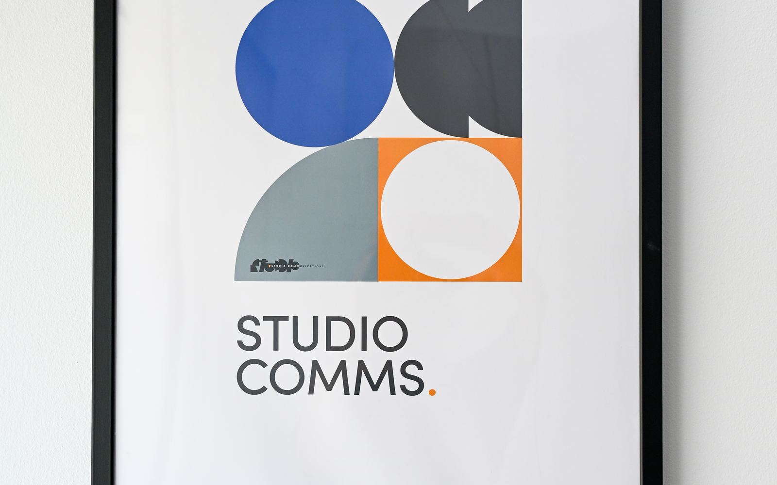 Framed STUDIO COMMUNICATIONS identity posters on the studio wall.